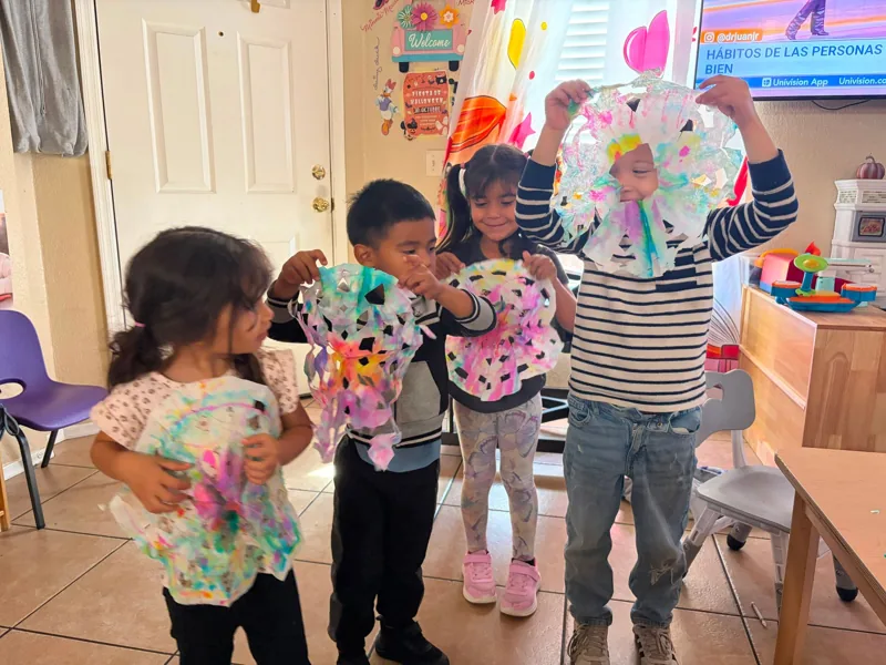 Preschoolers showing the paper crafts they made