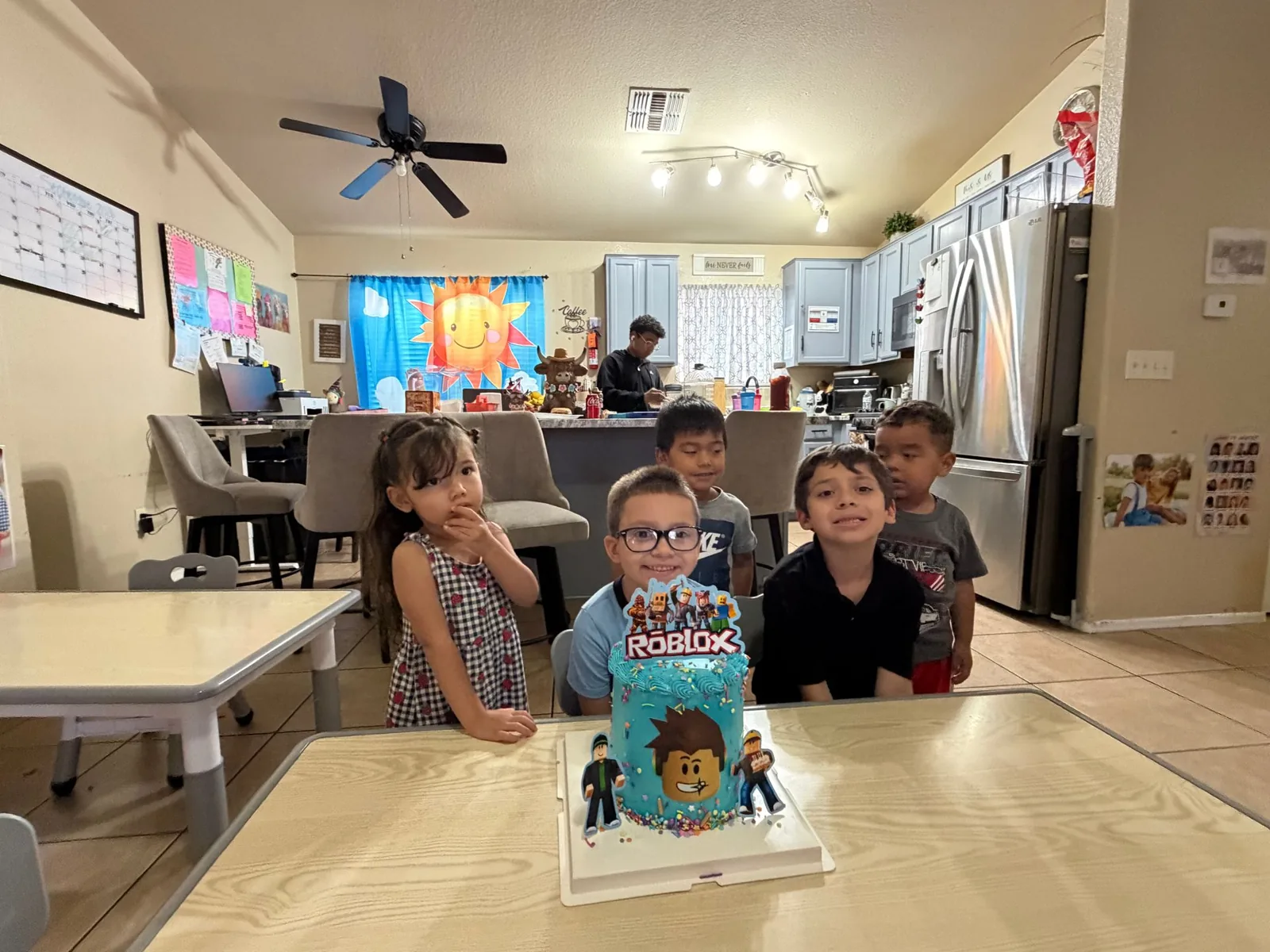 The playroom with tables, the kitchen and children celebrating a birthday